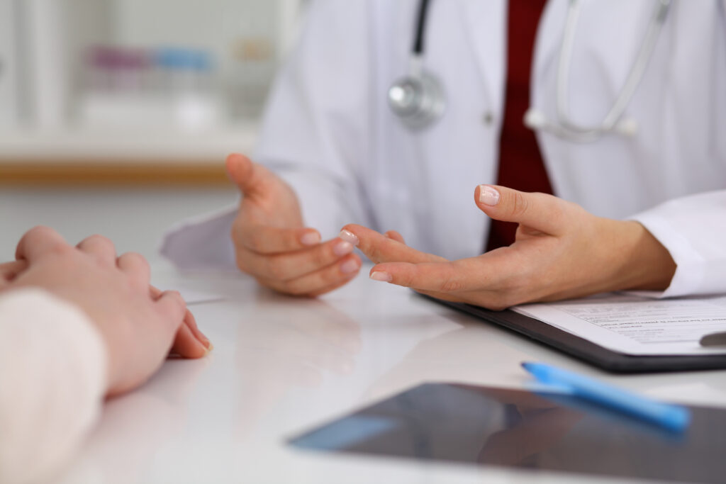 Close up of a doctor and patient hands while discussing medical records after health examination