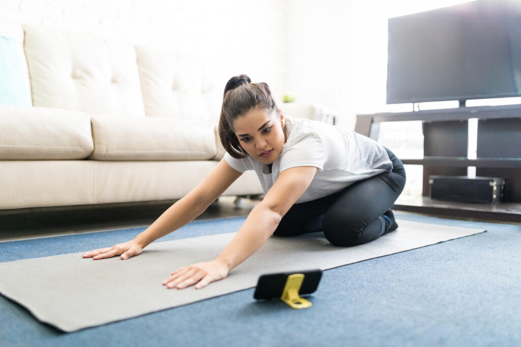 Woman repeating yoga exercise from online videos